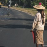 Flaggirl controlling traffic at the road construction near Bago in Myanmar